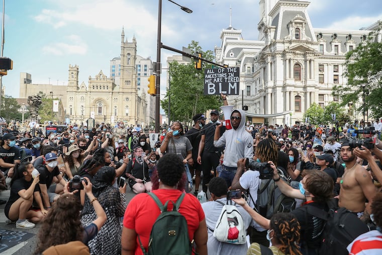 Hundreds of protesters take a knee and listen to speeches outside of City Hall in Philadelphia on Wednesday. It was the fifth day of protests against the killing of George Floyd at the hands of Minneapolis police.