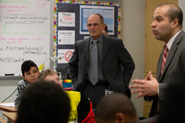 John Armato (left), Pottstown School District spokesman and school board member, stands alongside Superintendent Stephen Rodriguez as he addresses students at Pottstown Middle School. The district this past year lost $1 million in tax revenue from a local hospital and is facing a budget hole even with a proposed increase in state aid.